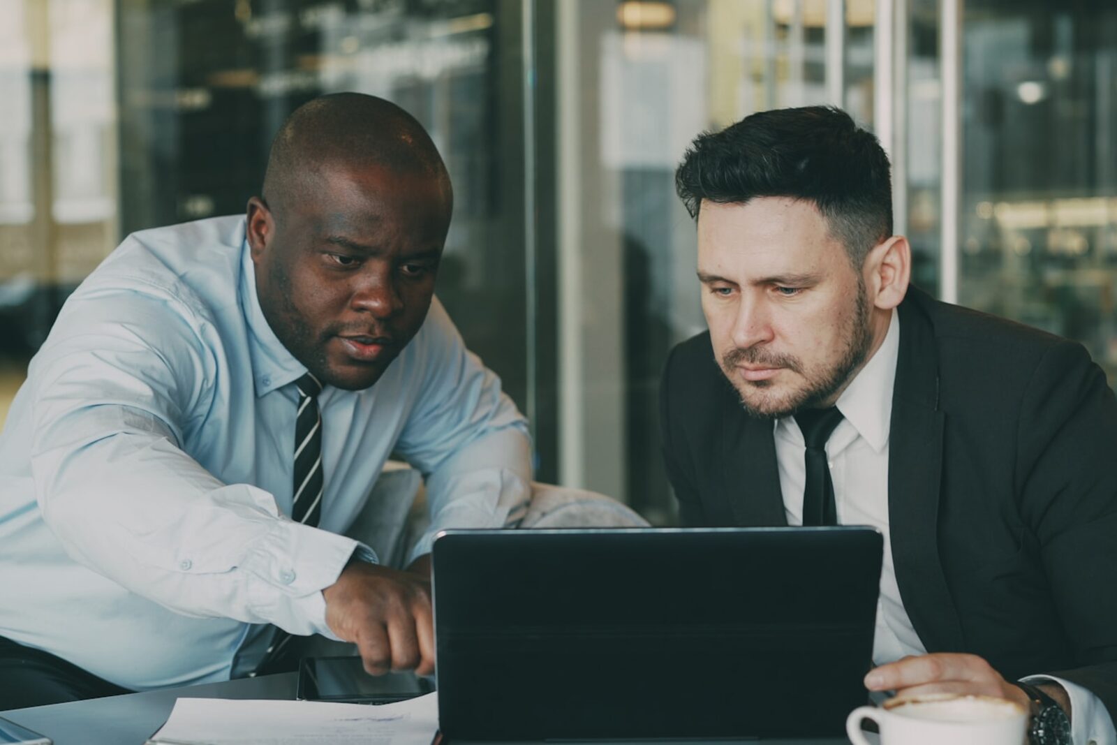 Two colleagues reviewing work together on a laptop